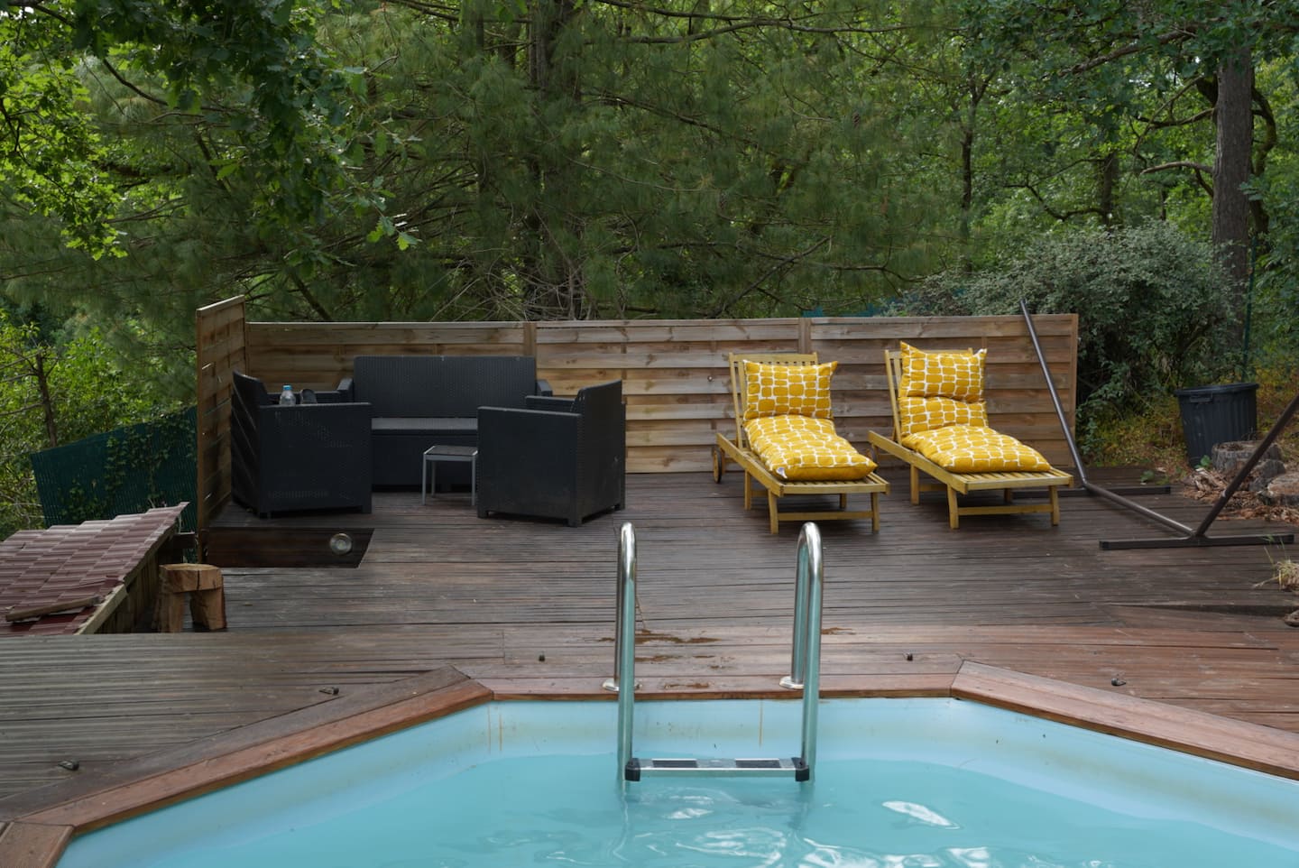 La piscine et sa terrasse en bois entourées d'arbres au Ranch Horse Paradise