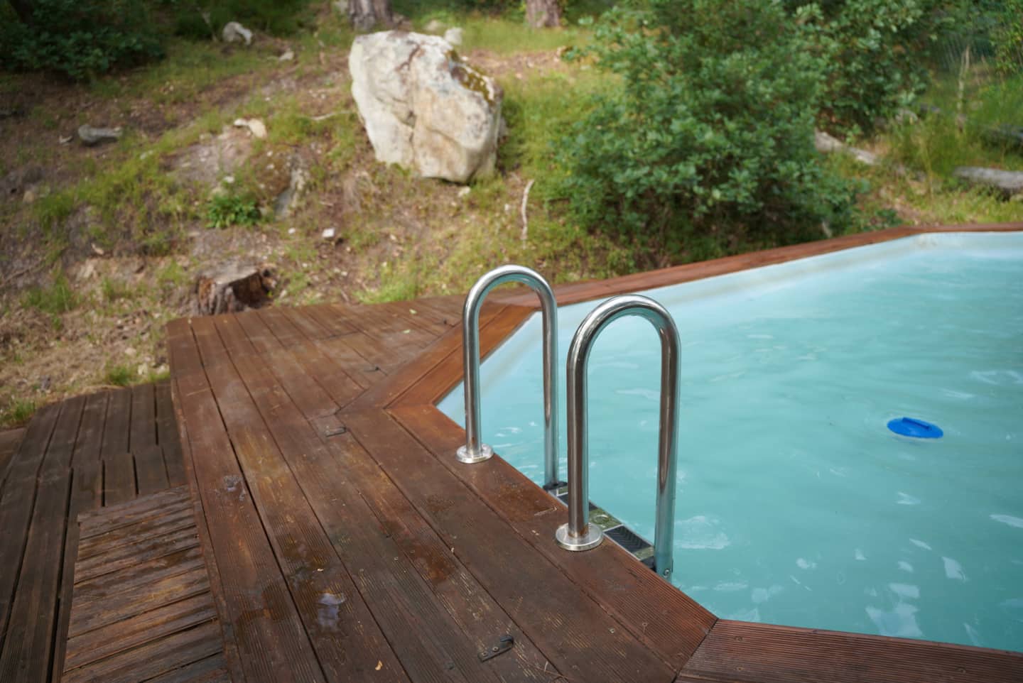 Détail de la piscine et de son échelle, au bord du bois